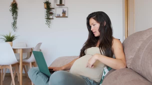 Vídeo en cámara lenta de una mujer embarazada asiática haciendo una videollamada con el portátil en casa - Metraje, vídeo