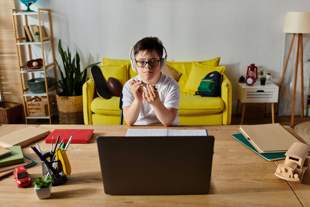 adorable chico con síndrome de Down usando portátil en el escritorio. - Foto, Imagen