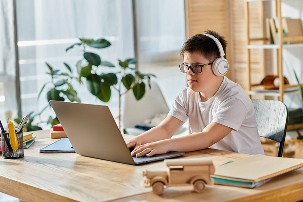 Niño con síndrome de Down con auriculares, ordenador portátil, ajuste en el hogar. - Foto, Imagen