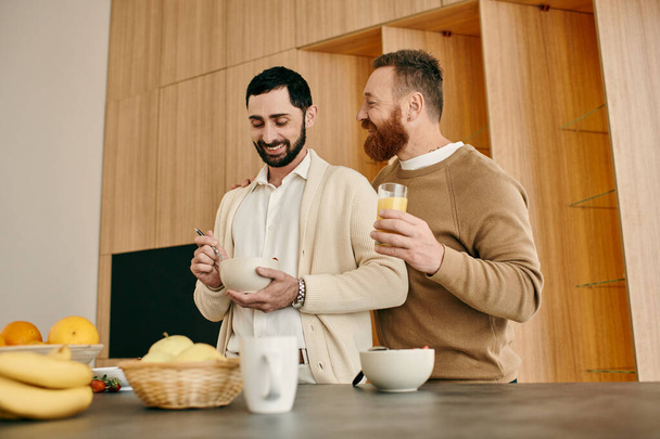 Deux hommes, un couple gay heureux, prennent le petit déjeuner ensemble dans une cuisine moderne, partageant un moment d'amour et de connexion. - Photo, image