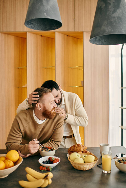 A joyful gay couple enjoying breakfast together at a table in their modern apartment. - Foto, imagen