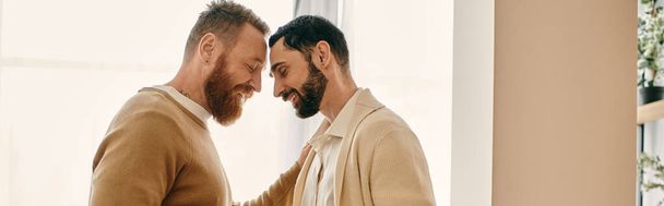 Two men in a modern apartment make eye contact, displaying love and connection in their relationship. - Photo, Image