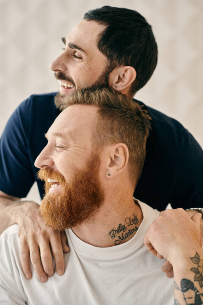 Kollarında dövmeleri olan iki adam sevgi ve şefkat gösterisinde sıcacık bir kucaklaşmayı paylaşıyor.. - Fotoğraf, Görsel