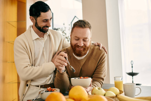 Una coppia gay felice si gode un pasto mattutino insieme in una cucina moderna. - Foto, immagini