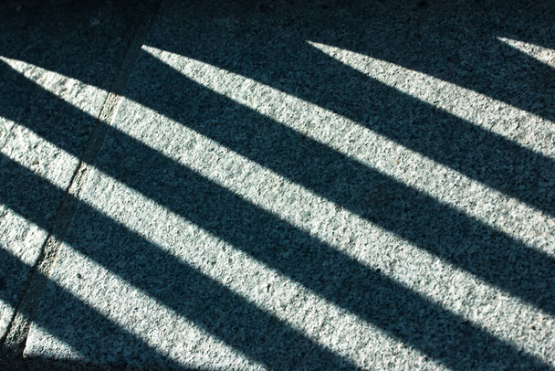 Fond minimal abstrait de lignes d'ombre contrastées sur une vue de dessus de plancher de ciment. Motifs et textures. Modèle de lumière et d'ombres. Rue urbaine. - Photo, image