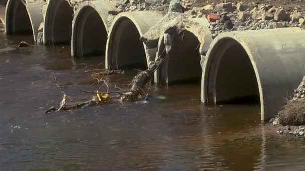 the river flows through the pipes in the dam. - Footage, Video