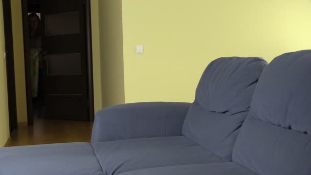 Terhes nő lány ül a kanapé és a takaró fedelet - Felvétel, videó