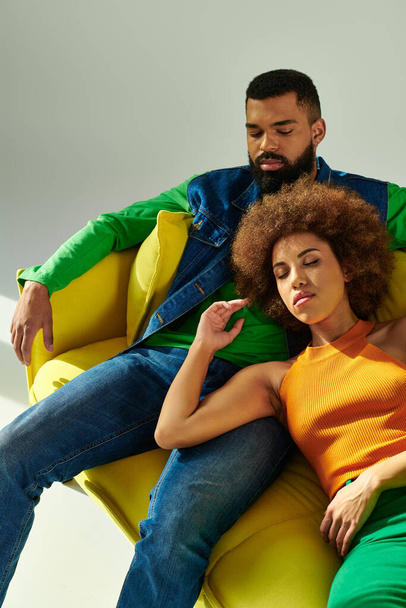 Afroamerykańscy przyjaciele w stylowych strojach cieszą się swoim towarzystwem podczas wypoczynku na kanapie - Zdjęcie, obraz