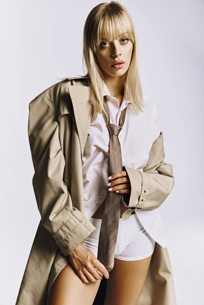 A stylish woman strikes a pose in short shorts and a trench coat. - Foto, Imagem