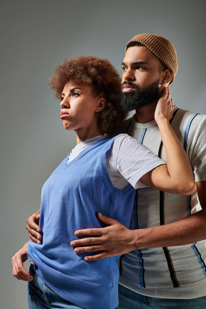 Африканський американець з бородою стоїть поруч з жінкою в стильному одязі, демонструючи міцний зв'язок дружби. - Фото, зображення