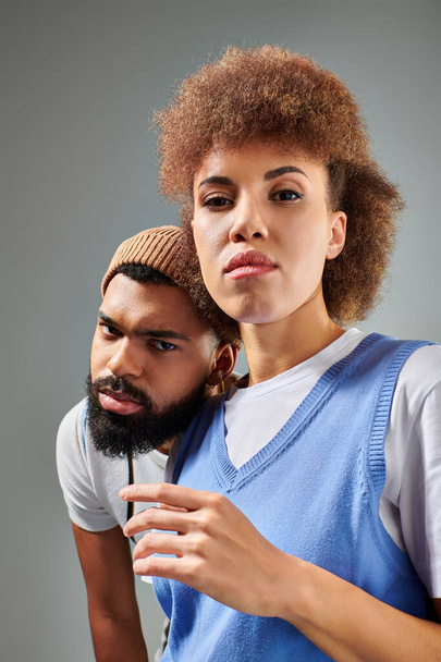 Un hombre y una mujer afroamericanos, vestidos con ropa elegante, posan juntos - Foto, imagen