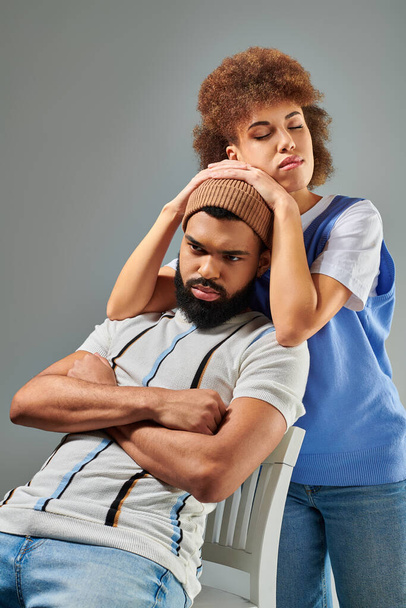 Afroameričan muž a žena ve stylovém oblečení sedí, ukazuje krásu přátelství mezi pohlavími. - Fotografie, Obrázek