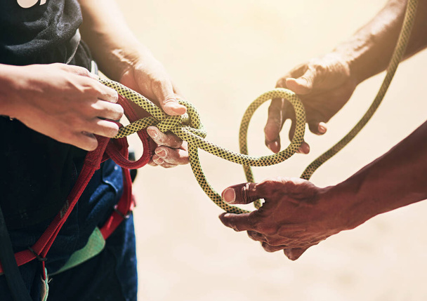 Rock climbing, nature and hands of people with rope for training, exercise and outdoor extreme sports. Fitness, travel and friends with harness, equipment or gear for adventure, workout and challenge. - Photo, Image