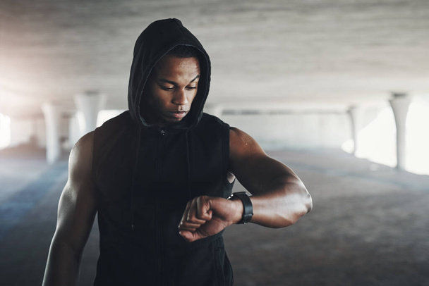 Black man, athlete and smart watch for exercise monitor in parking garage for heart rate, calories or cardio. Male person, wrist and checking for fitness training or healthy progress, app or goals. - Photo, Image