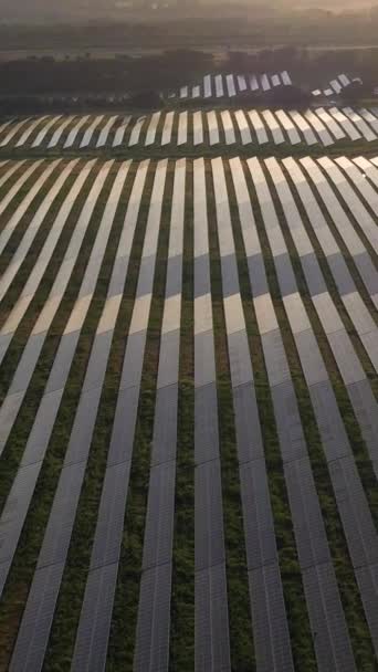 Duże pole fotowoltaicznych paneli słonecznych o zachodzie słońca w Portugalii. Odbicie światła słonecznego. Widok z lotu ptaka. Dron porusza się bokiem. Pionowe wideo - Materiał filmowy, wideo