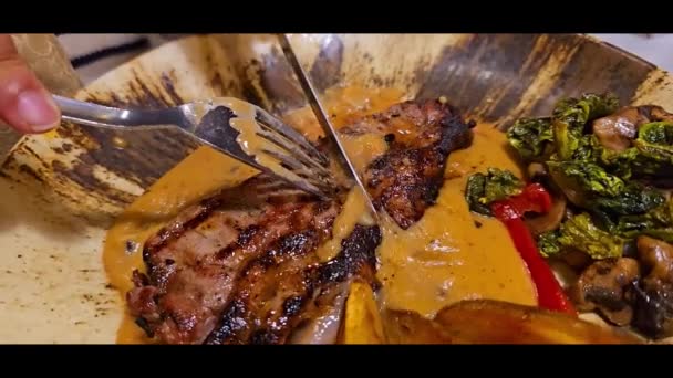 Roaststeak vom Grill medium rare serviert mit Kartoffeln und Salat mit Champignons schwarzer Pfeffer Sauce in einem Restaurant - Filmmaterial, Video