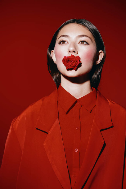 Γυναικεία κομψότητα: Ένα εντυπωσιακό πορτρέτο ενός νεαρού μοντέλου μόδας με κόκκινα χείλη και ρετρό χτένισμα, ποζάροντας σε λευκό φόντο στούντιο - Φωτογραφία, εικόνα