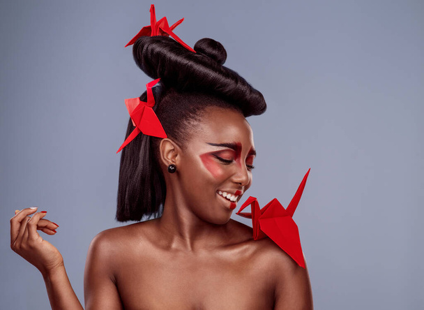 Tyyli, kulttuuri ja origami musta nainen studiossa eristetty harmaalla pohjalla perinne. Kauneus, lintu ja hymy onnellisella afrikkalaisella mallilla meikissä kosmetiikkaan, fuusioon ja inspiraatioon. - Valokuva, kuva