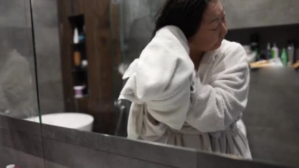 Азіатська жінка сушить після душу у ванній. - Кадри, відео