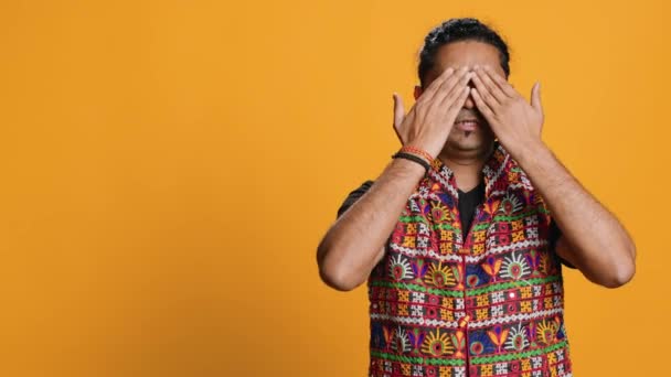 Indian man covering eyes, ears and mouth with hands, imitating the three wise monkeys. Person doing dont see, dont hear and dont speak gesturing concept, studio background - Footage, Video