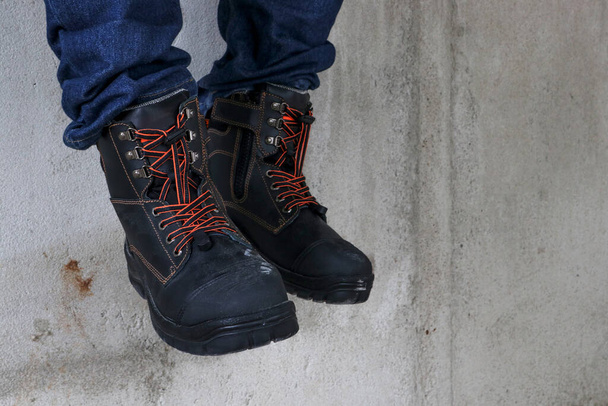 Um trabalhador de construção usa botas de couro marrom que parece muito legal e elegante - Foto, Imagem