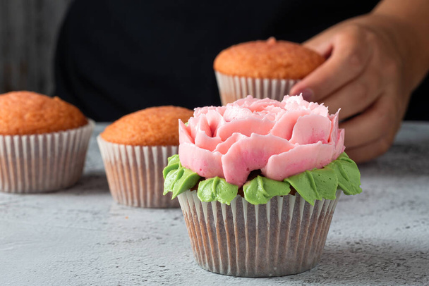 Colorful cupcakes with flower shaped decorations made with buttercream frosting. - Photo, Image