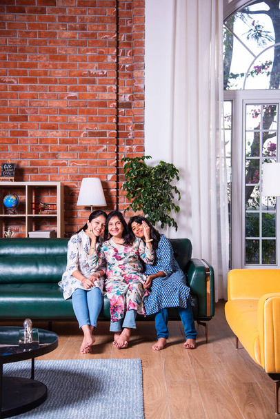 幸せなインドアジアの肖像画 女性の3世代,おばあちゃん,娘と孫娘がソファに座っています - 写真・画像