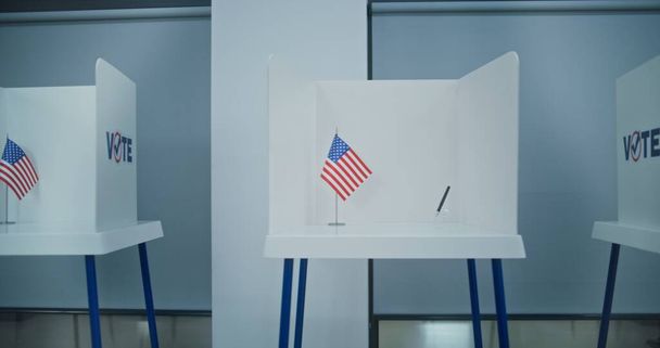 Dolly disparó de las cabinas de votación con el logotipo de la bandera americana en la oficina de la estación de votación ligera. Día Nacional de Elecciones en los Estados Unidos de América. Razas políticas de candidatos presidenciales estadounidenses. Democracia. - Foto, Imagen