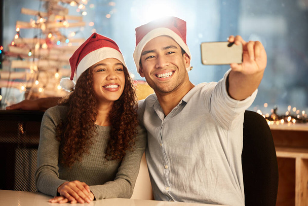 Pari, puhelin ja selfie jouluksi, juhla ja puolue tai työtapahtuma toimistossa yhdessä. Mies, nainen ja älypuhelin sosiaalisen median, onnea ja muistia yöllä lomalla tai lomalla. - Valokuva, kuva