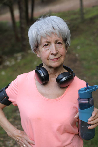 Senior mujer activa sosteniendo botella de agua - Foto, imagen