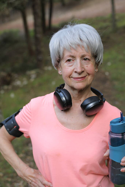 Senior active woman holding water bottle - Photo, Image