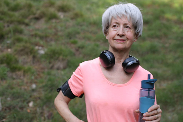 Senior active woman holding water bottle - Photo, Image