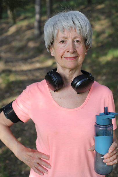 Donna anziana attiva in possesso di bottiglia d'acqua - Foto, immagini