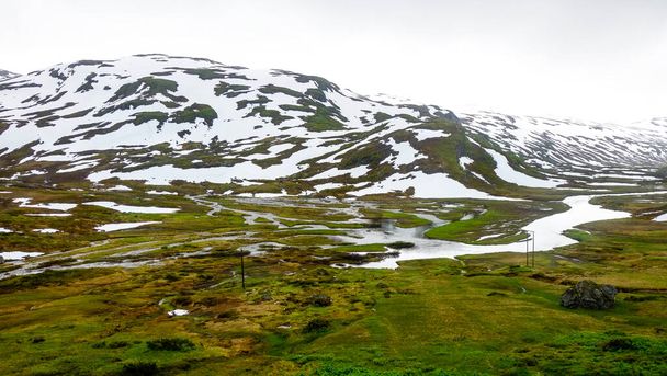 Зимовий природний пейзаж засніженого гірського пагорба, вкритого льодовим снігом в сільській місцевості Норвегії - Фото, зображення