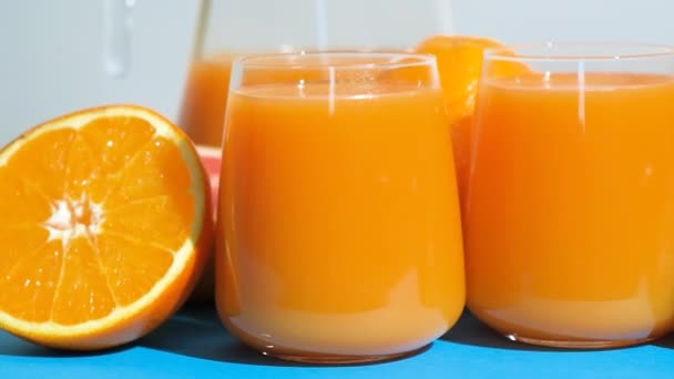 Мульти-фруктовые соки в бокалах среди свежих фруктов - Кадры, видео