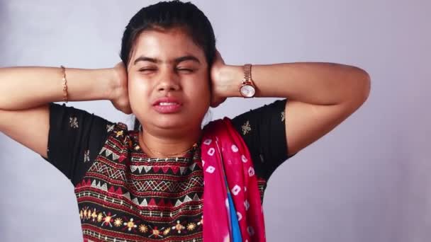 Hezký mladý indián žena zakrývá uši, aby se zabránilo hlasitý hluk na bílém pozadí - Záběry, video