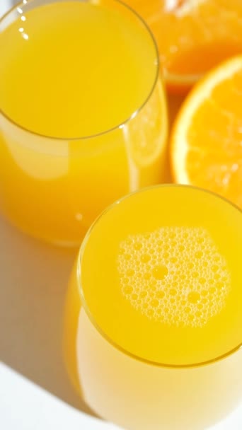 Sinaasappelsap in een glas. Verticale slow motion. - Video