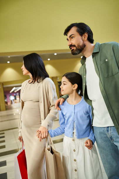 Szczęśliwa rodzina z torbami na zakupy, ciesząca się dniem spędzonym razem w centrum handlowym. - Zdjęcie, obraz