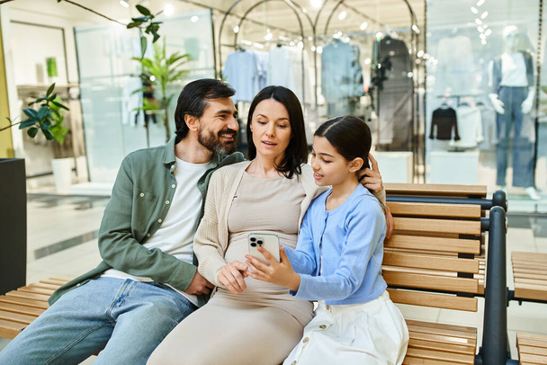 Una famiglia di generazioni si siede insieme su una panchina in un vivace centro commerciale, godendo di un momento di intimità. - Foto, immagini