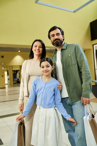 Una familia alegre con bolsas de compras paseando tranquilamente por un bullicioso centro comercial en un fin de semana lleno de diversión. - Foto, imagen