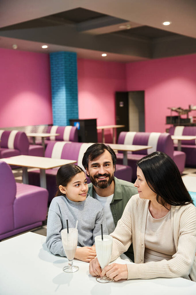 Eine glückliche Familie sitzt an einem Restauranttisch und genießt eine gemeinsame Zeit in einem modernen Ambiente am Wochenende. - Foto, Bild