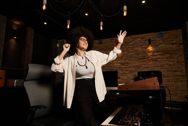 Μια γυναίκα με χαρά απλώνει τα χέρια της σε ένα στούντιο ηχογράφησης κατά τη διάρκεια μιας πρόβας μουσικής μπάντας.. - Φωτογραφία, εικόνα