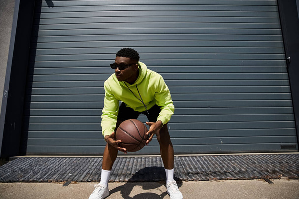 Handsome man in yellow hoodie with basketball. - Photo, Image