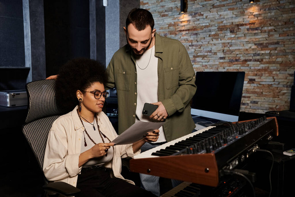 Mężczyzna i kobieta pracują razem w studiu nagraniowym, udoskonalając swoją muzykę do nadchodzącego występu. - Zdjęcie, obraz
