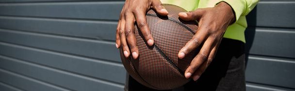 Elinde basketbol topuyla şık giyinmiş Afro-Amerikan bir adam.. - Fotoğraf, Görsel