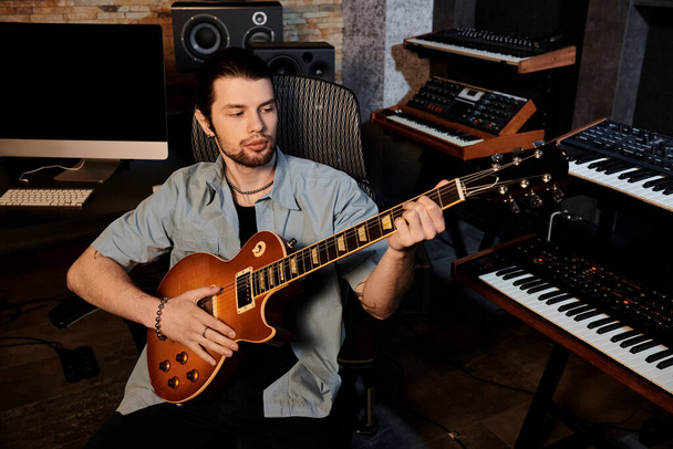 Un hombre experto toca una guitarra eléctrica con pasión en un estudio de grabación durante un ensayo de la banda de música. - Foto, Imagen