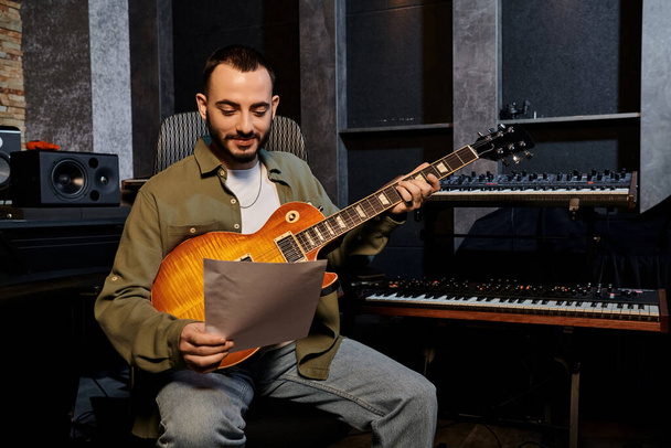 Egy férfi, aki elektromos gitározik egy hangstúdióban egy zenekari próbán.. - Fotó, kép