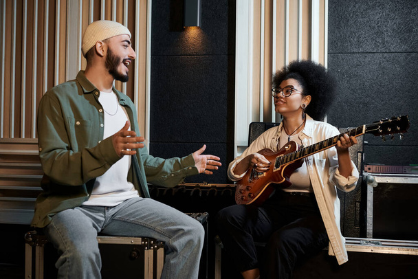 Un uomo e una donna suonano appassionatamente le chitarre in uno studio di registrazione, creando musica accattivante insieme. - Foto, immagini