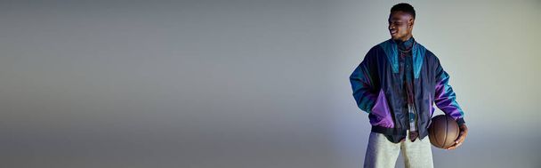 Κομψός Αφροαμερικάνος με μωβ σακάκι που κρατάει το μπάσκετ. - Φωτογραφία, εικόνα
