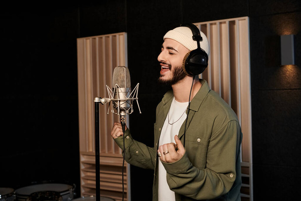 Egy férfi szenvedélyesen énekel egy mikrofonba egy stúdióban egy zenekari próba alatt.. - Fotó, kép